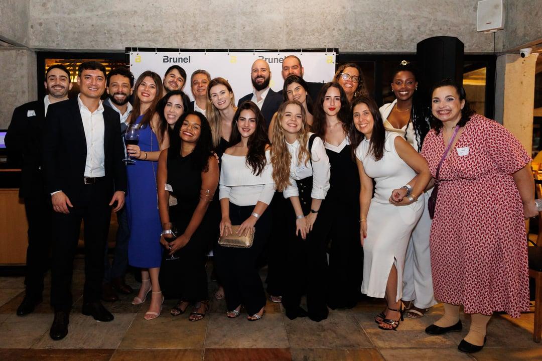Brunel Brazil team poses for photo infront of branded backdrop